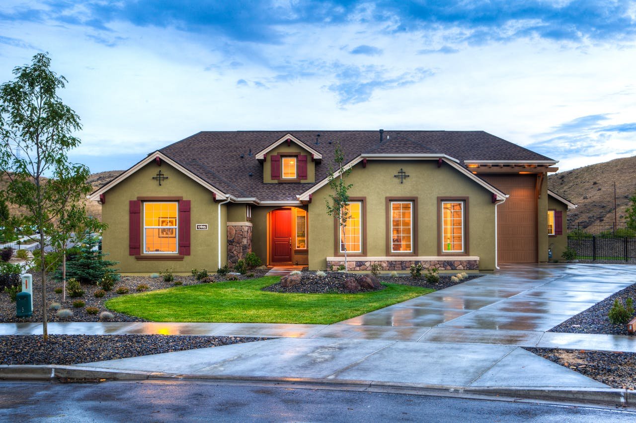 gallery-3 Beautifully illuminated modern home exterior with a lush lawn and wet driveway in Boise, Idaho.