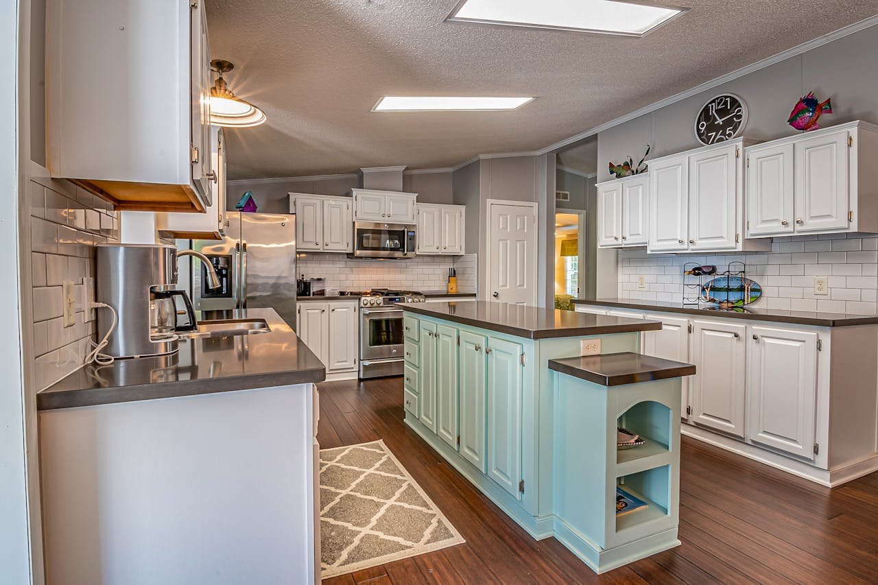 ours-journey A spacious kitchen featuring white cabinets, modern appliances, and a central island with seating.
