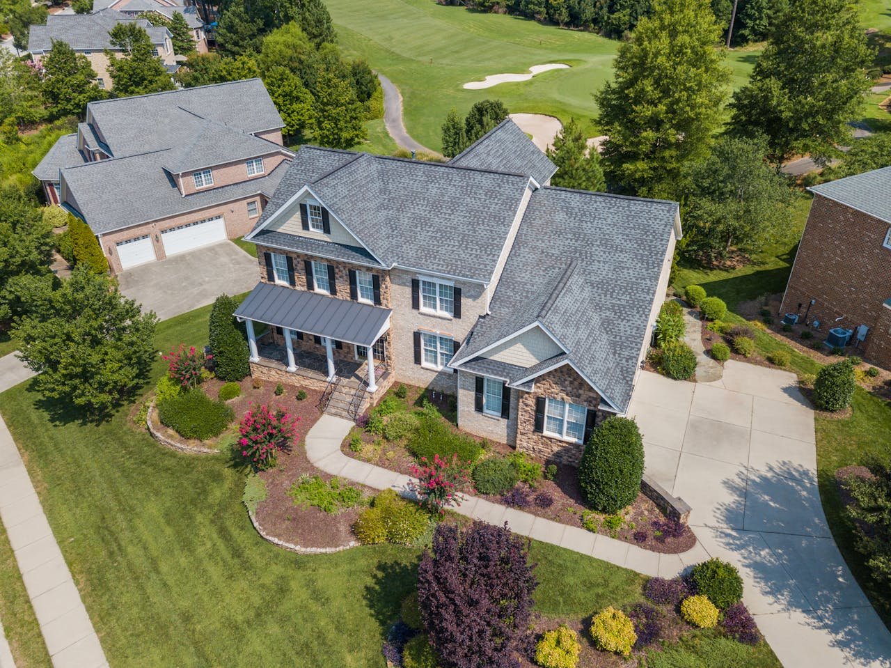 gallery-4 Bird's-eye view of a beautiful suburban home in Raleigh, NC, with lush landscaping.